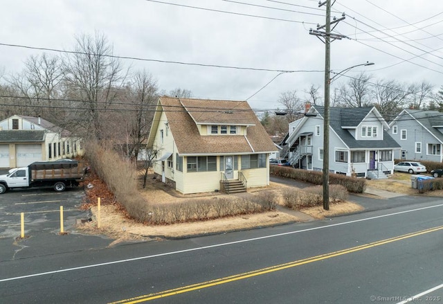 view of front of property with entry steps, a residential view, and roof with shingles