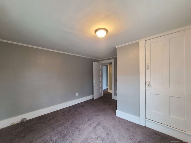 unfurnished bedroom with carpet flooring, crown molding, and baseboards