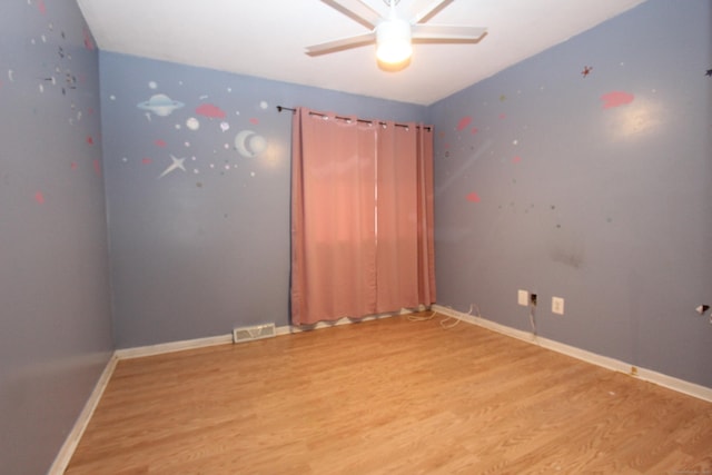 empty room with ceiling fan, light wood-type flooring, visible vents, and baseboards