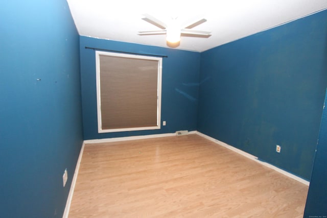 unfurnished room featuring ceiling fan, wood finished floors, and baseboards