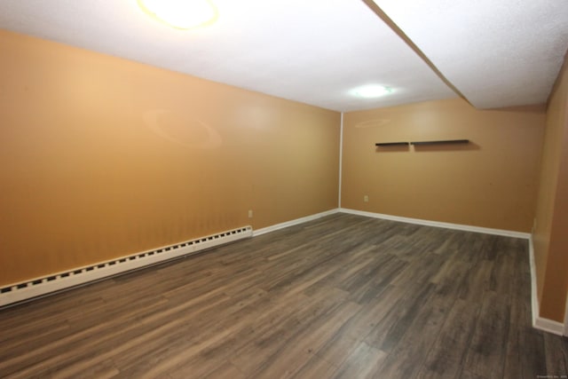 unfurnished room with dark wood-style floors, a baseboard radiator, and baseboards