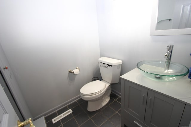 bathroom featuring baseboards, visible vents, toilet, tile patterned floors, and vanity