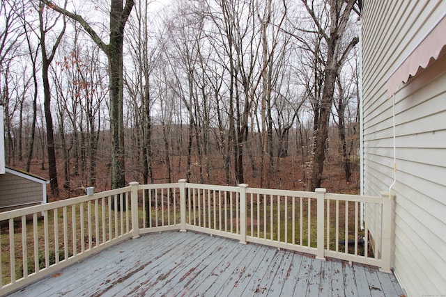 wooden terrace featuring a wooded view