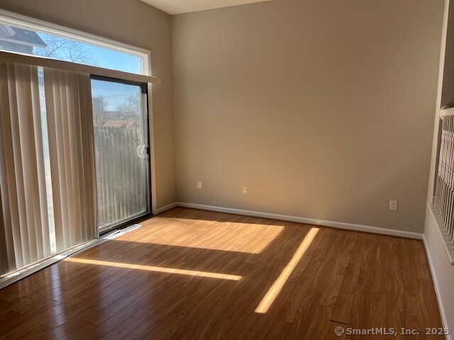 spare room with wood finished floors and baseboards