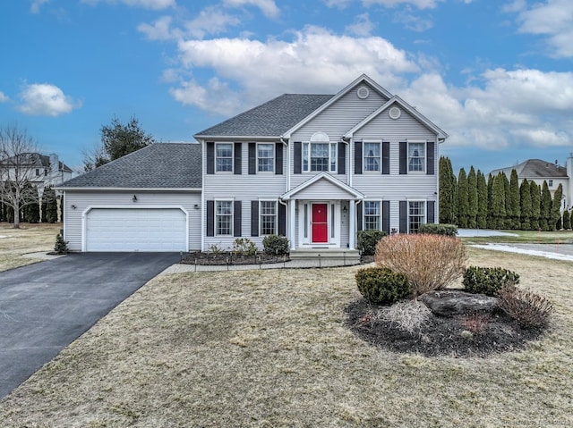 view of front of home with aphalt driveway, a shingled roof, and a garage