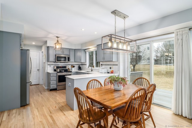 dining space with recessed lighting and light wood-style flooring