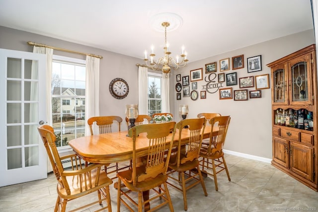 dining space with an inviting chandelier, light tile patterned floors, and baseboards