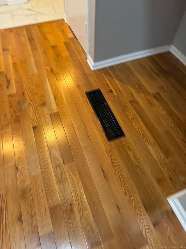 room details with visible vents, baseboards, and wood finished floors