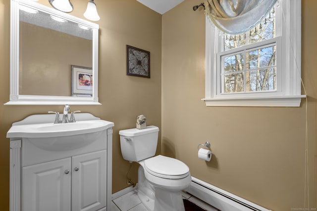 bathroom with a baseboard heating unit, baseboards, vanity, and toilet