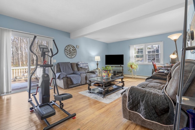 living area featuring light wood finished floors, a baseboard heating unit, and beamed ceiling