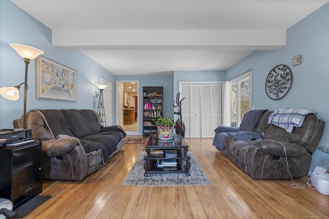 living area featuring beam ceiling and hardwood / wood-style flooring