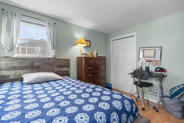 bedroom with baseboards, a closet, and wood finished floors