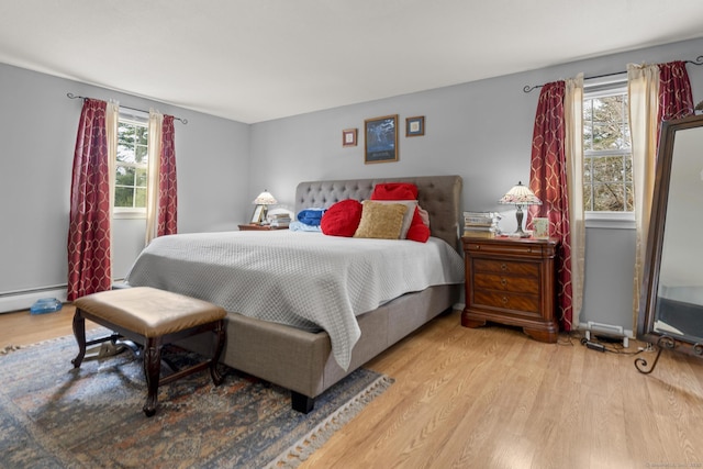 bedroom featuring baseboard heating and wood finished floors