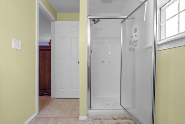 full bathroom featuring a stall shower, tile patterned flooring, and baseboards