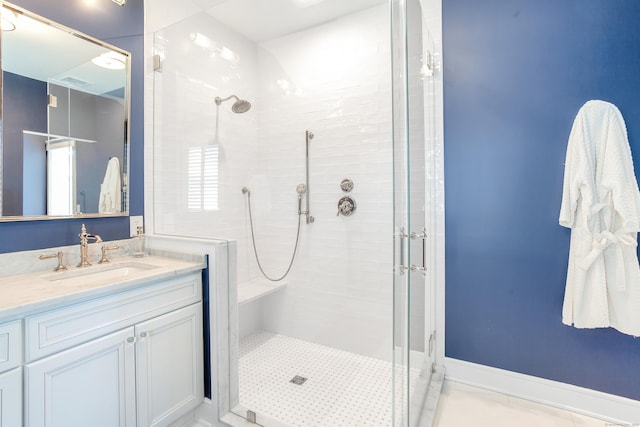 full bath with tiled shower, vanity, and baseboards