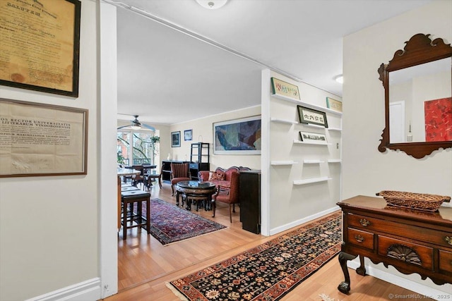 corridor featuring baseboards and wood finished floors