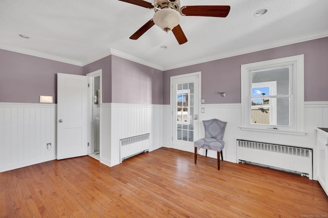 sitting room featuring a wainscoted wall and radiator heating unit