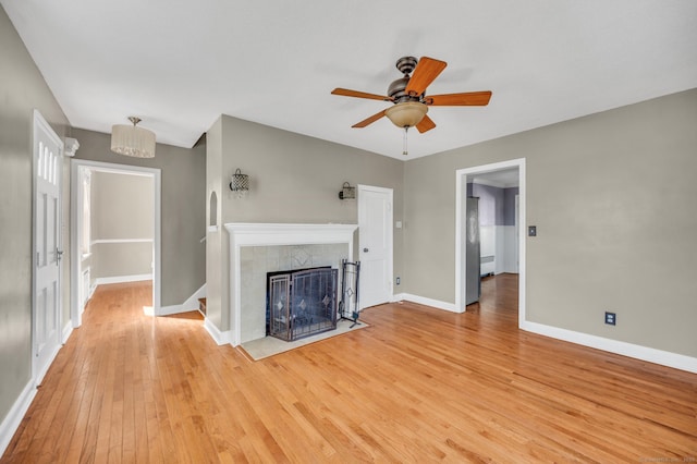 unfurnished living room with a fireplace, light wood-style flooring, and baseboards