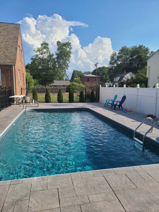 view of swimming pool with a patio, fence, and a fenced in pool