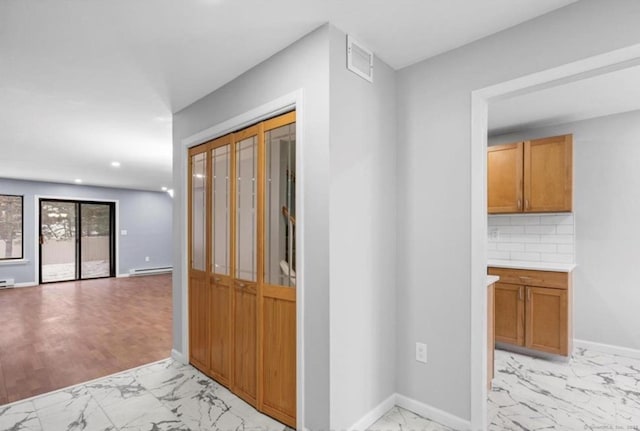 hallway featuring a baseboard radiator, marble finish floor, visible vents, and baseboards