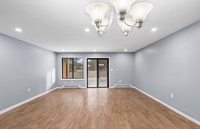 empty room featuring baseboards, a chandelier, and baseboard heating