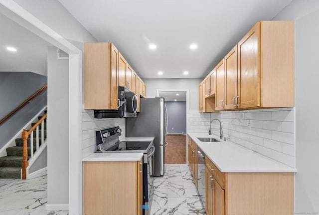 kitchen with marble finish floor, appliances with stainless steel finishes, a sink, and recessed lighting