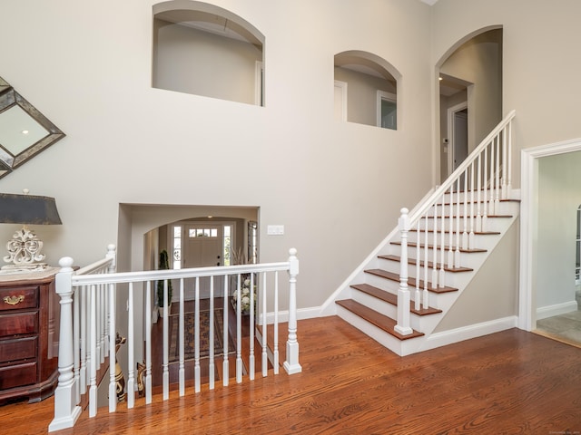 157 N Ave, Westport, CT 06880 - stairway featuring baseboards, a towering ceiling, and wood finished floors