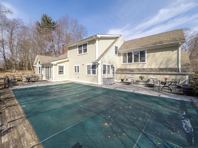 157 N Ave, Westport, CT 06880 - rear view of property featuring a patio area, a shingled roof, and a covered pool
