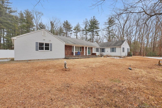 single story home featuring brick siding, fence, and a front lawn