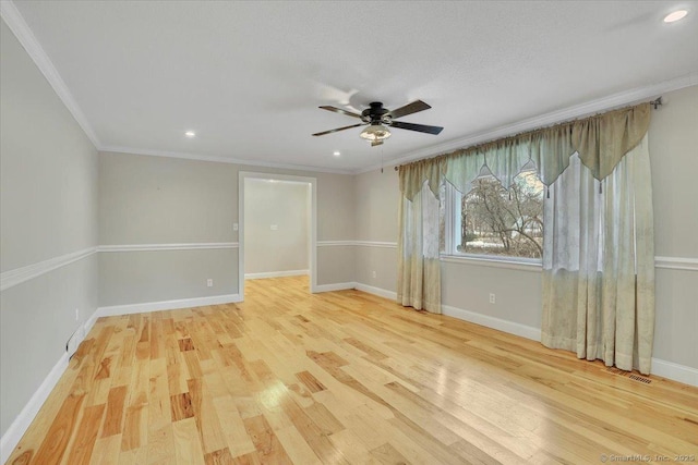 unfurnished room featuring ornamental molding, wood finished floors, visible vents, and baseboards