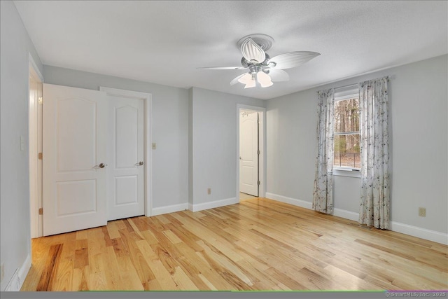 unfurnished bedroom featuring ceiling fan, wood finished floors, and baseboards