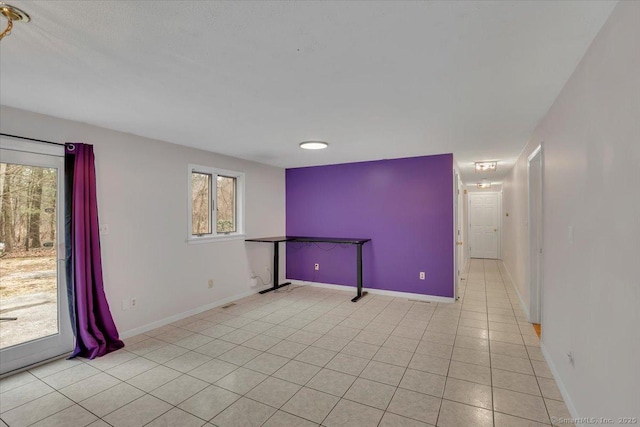 empty room featuring light tile patterned flooring and baseboards