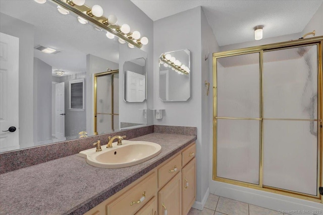 bathroom with visible vents, tile patterned floors, a textured ceiling, vanity, and a shower stall