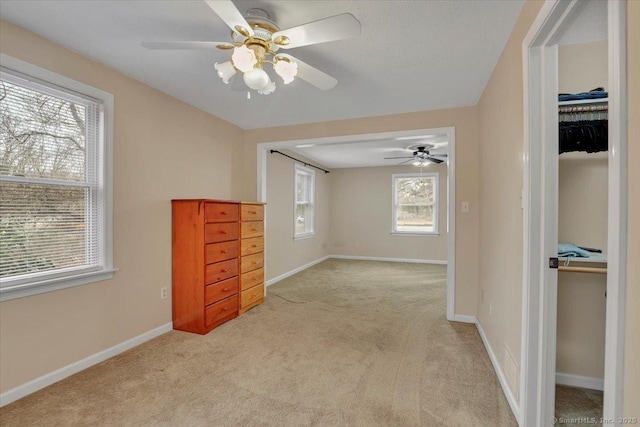 bedroom with baseboards, a ceiling fan, and light colored carpet