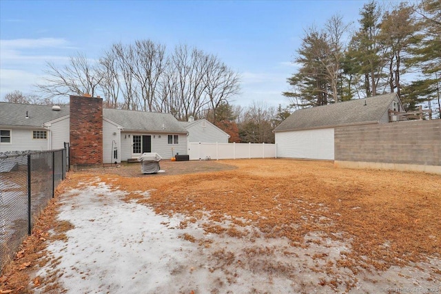 rear view of property with a chimney and a fenced backyard