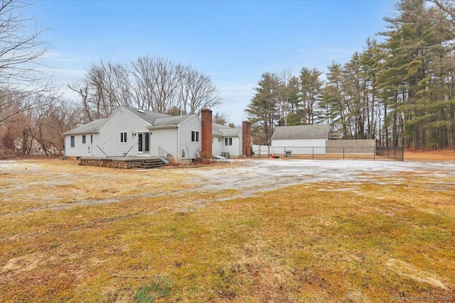 view of property exterior with a chimney, fence, and a lawn