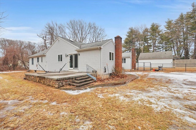 rear view of house featuring a patio, a chimney, and fence