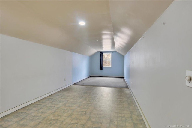 additional living space with vaulted ceiling, tile patterned floors, and baseboards