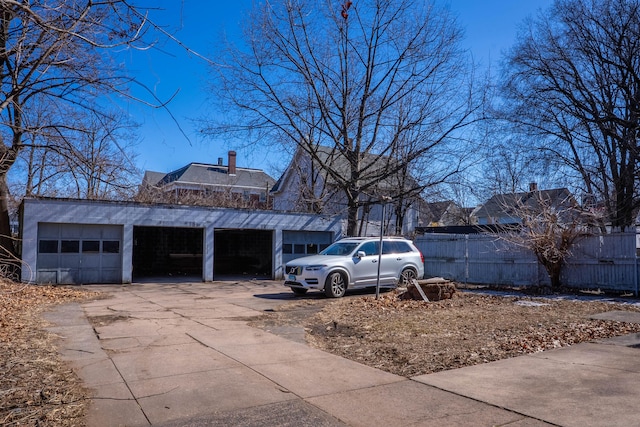 view of property exterior featuring driveway, a chimney, and fence