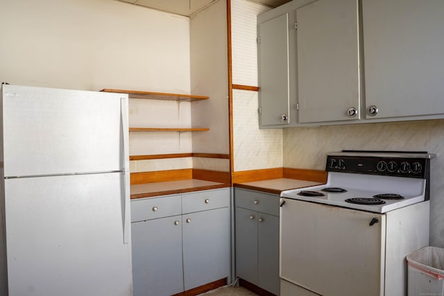 kitchen with open shelves, white appliances, and gray cabinetry