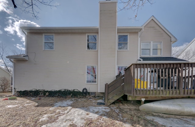 rear view of property featuring a chimney and a wooden deck