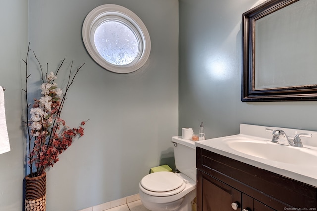 half bathroom with toilet, tile patterned flooring, and vanity