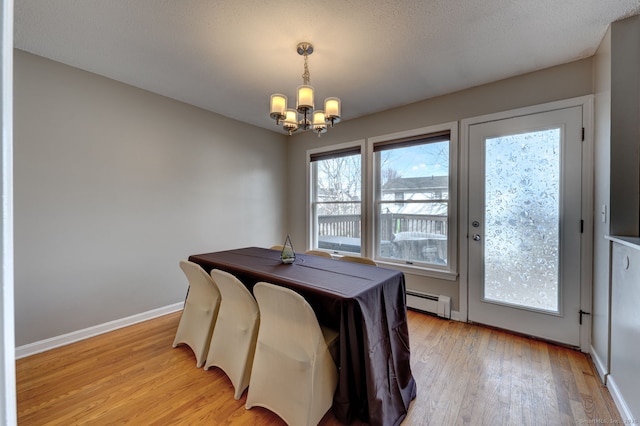 dining area with baseboards, a baseboard radiator, light wood-style flooring, and an inviting chandelier