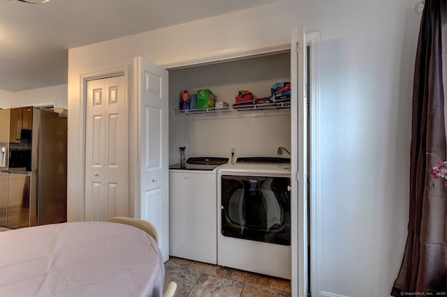 laundry room with laundry area, separate washer and dryer, and stone finish flooring