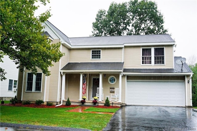 view of front of home with an attached garage, aphalt driveway, and a front yard