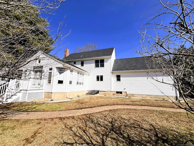 back of house featuring roof with shingles