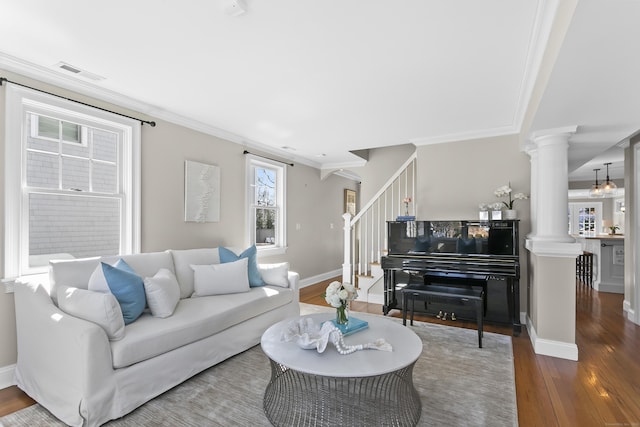 living area with visible vents, stairway, ornamental molding, ornate columns, and hardwood / wood-style flooring