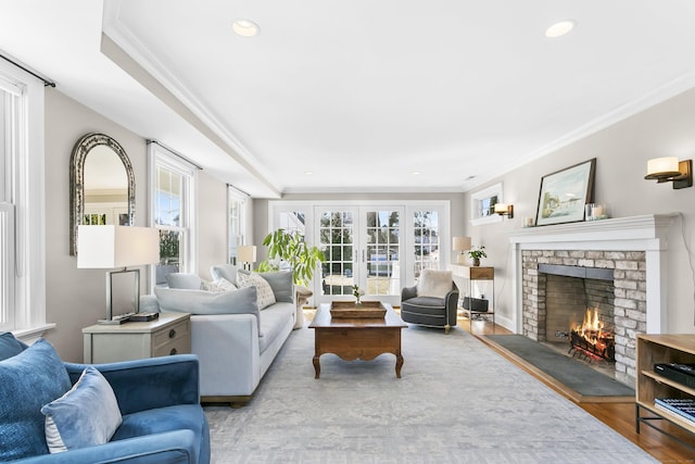 living area featuring crown molding, recessed lighting, a fireplace, and wood finished floors