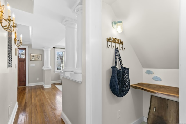 corridor with vaulted ceiling, decorative columns, baseboards, and hardwood / wood-style flooring