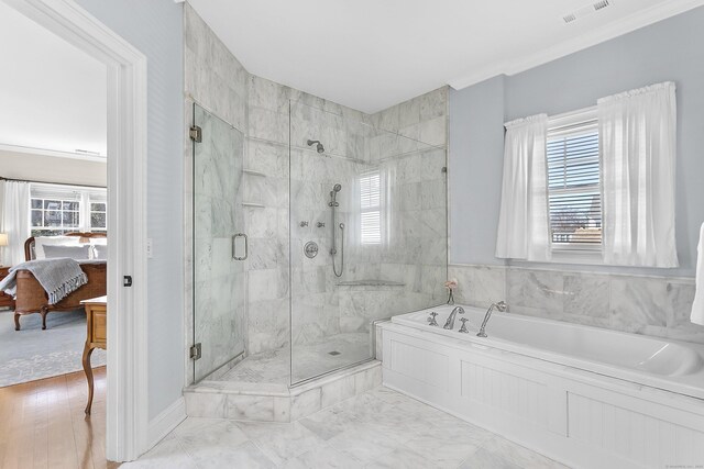 ensuite bathroom featuring a wealth of natural light, ensuite bath, visible vents, and a bath